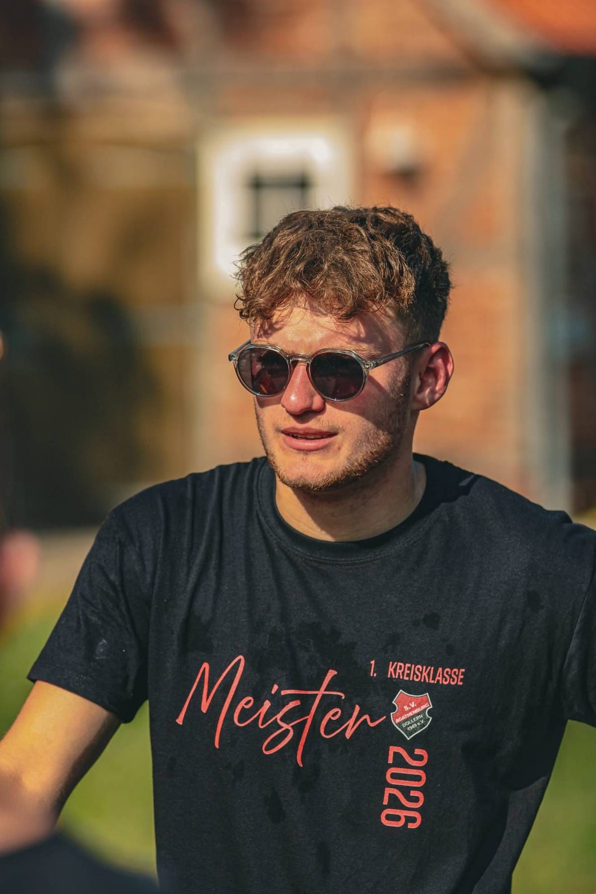 Spieler mit Sonnenbrille im Meister-Shirt im warmen Abendlicht