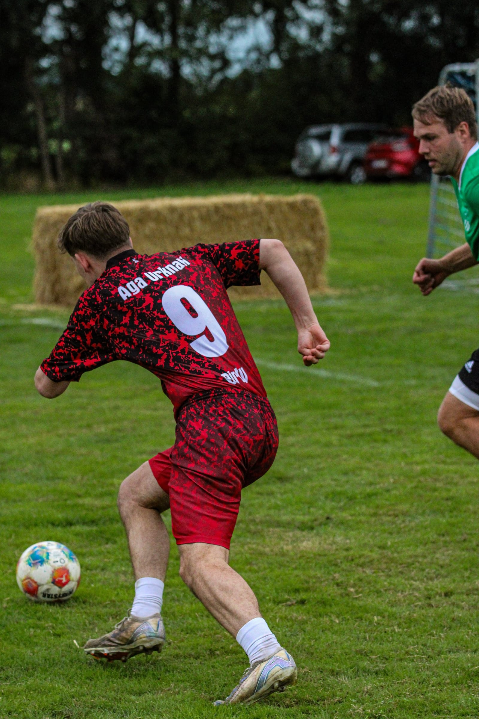 Spieler mit der Rückennummer 9 dribbelt den Ball, von hinten fotografiert