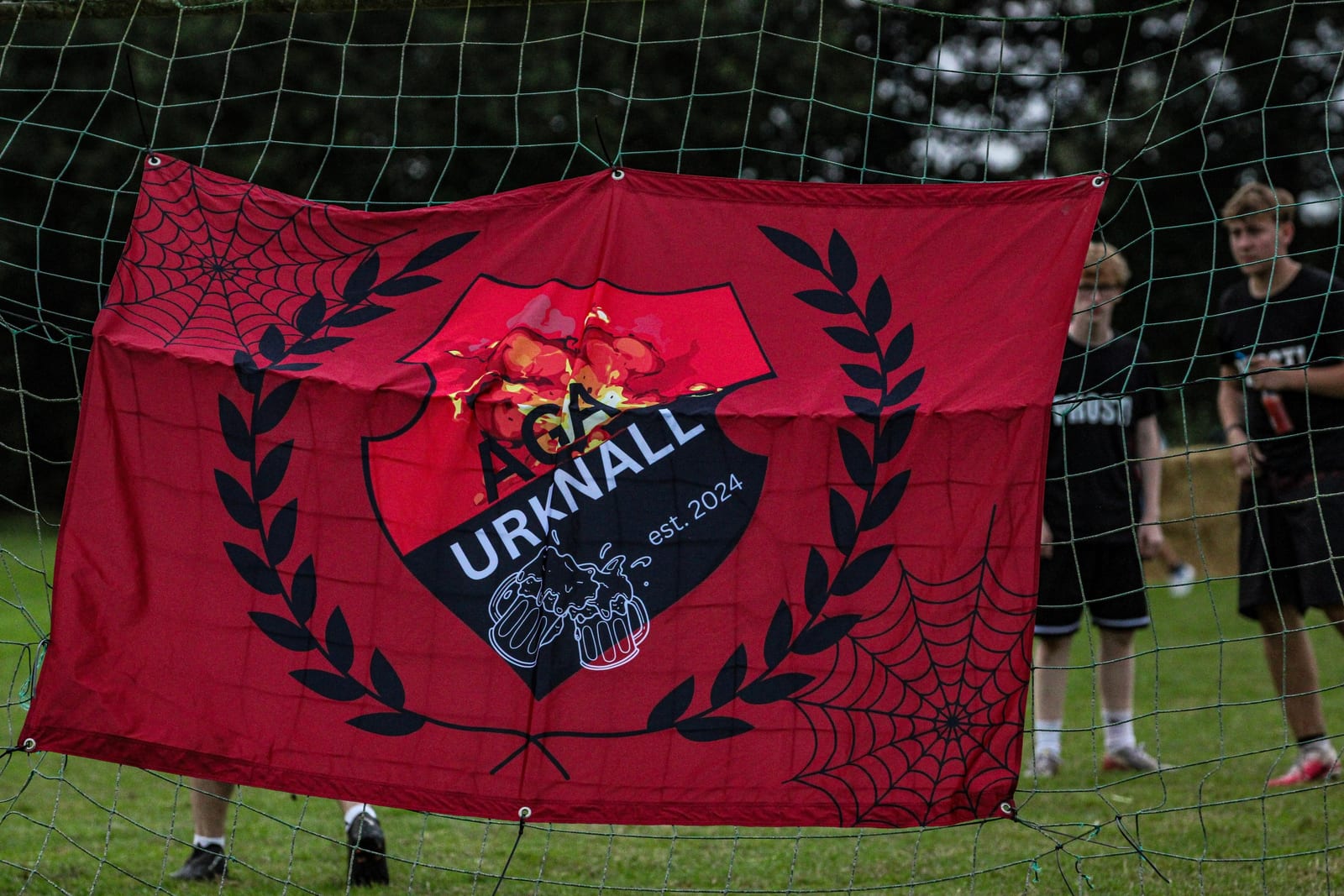 Rote Fahne mit dem Wappen von Aga Urknall hängt am Tornetz