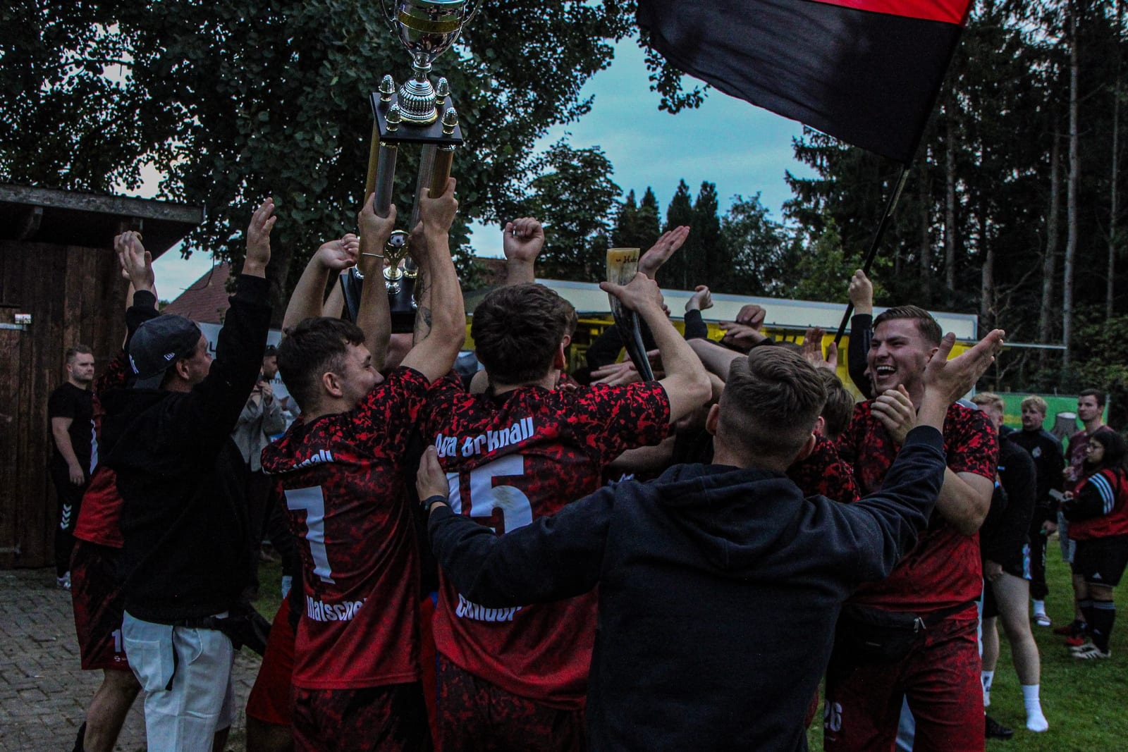 Der Pokal wird mitten in der jubelnden Mannschaft in die Höhe gehalten